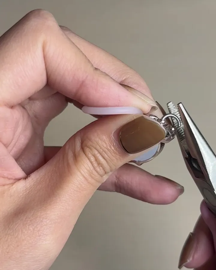 ペンチでアクリルキーホルダーに金具を取り付ける様子