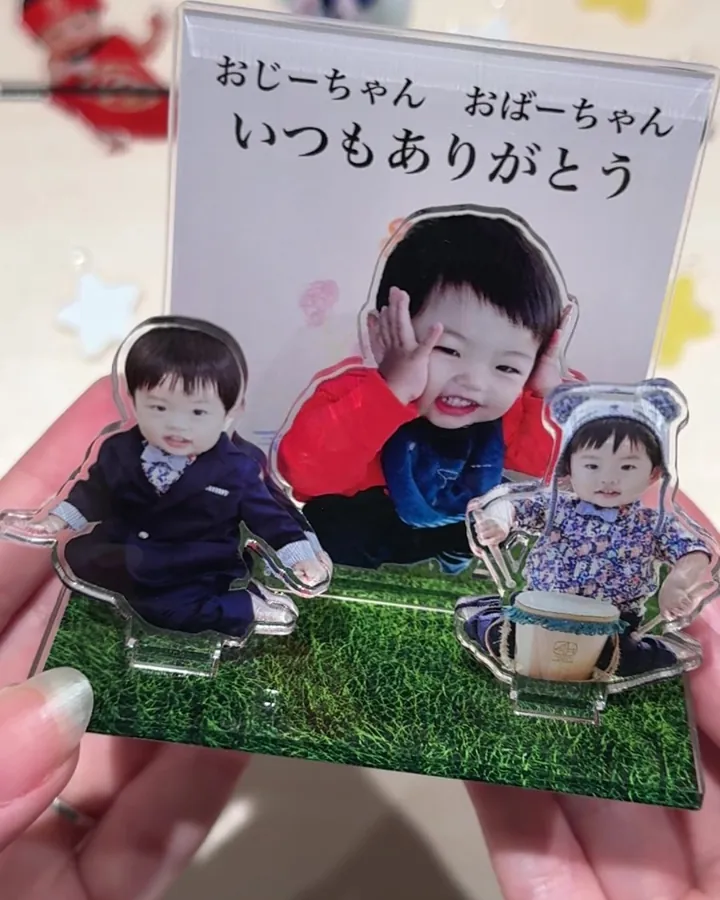 人物ごとに切り抜いた子どもの写真を芝生の台座に並べたアクリルスタンド