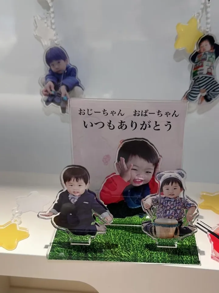 子どもの写真のキーホルダーとアクリルスタンドを棚に飾った様子