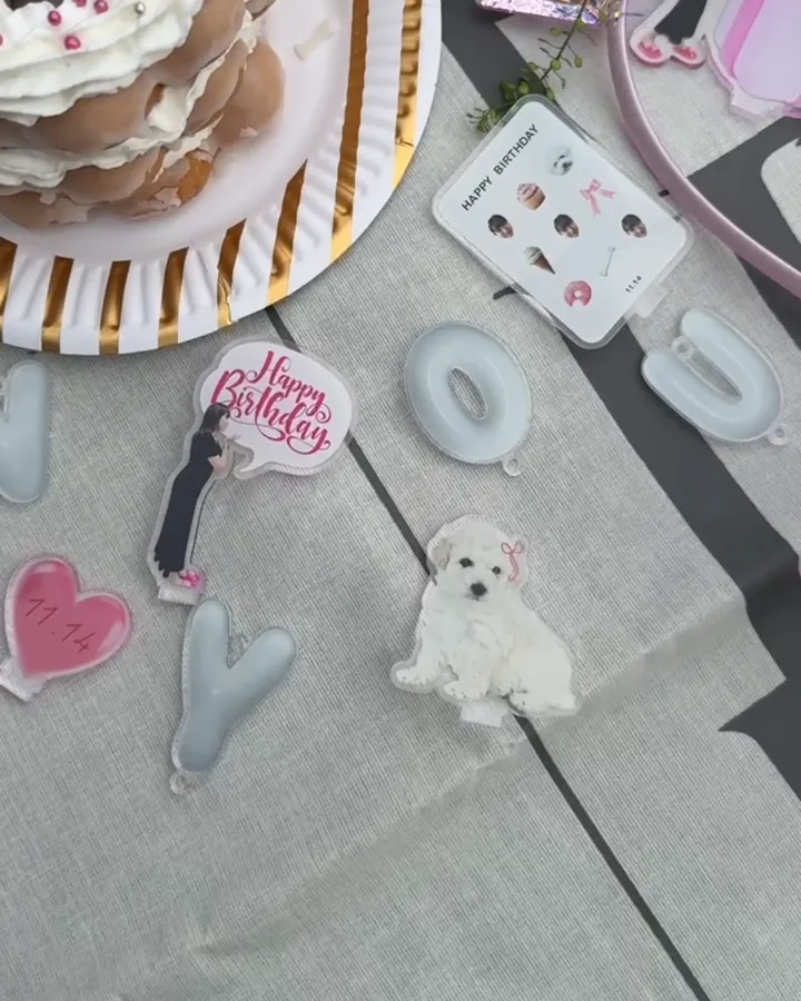 誕生日のテーブルに飾った犬のアクリルチャームとHappy Birthdayのパーツ