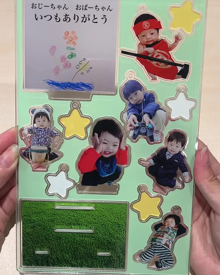 1枚のプレートに子どもの写真のスタンドや星形のチャームを並べたアクリルプレート